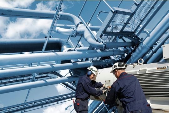 Two oil and gas workers with large fuel pipelines - GettyImages-1148113049.jpg